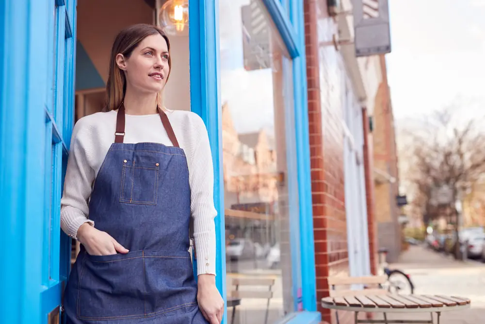 A shop owner standing in the doorway of her own business